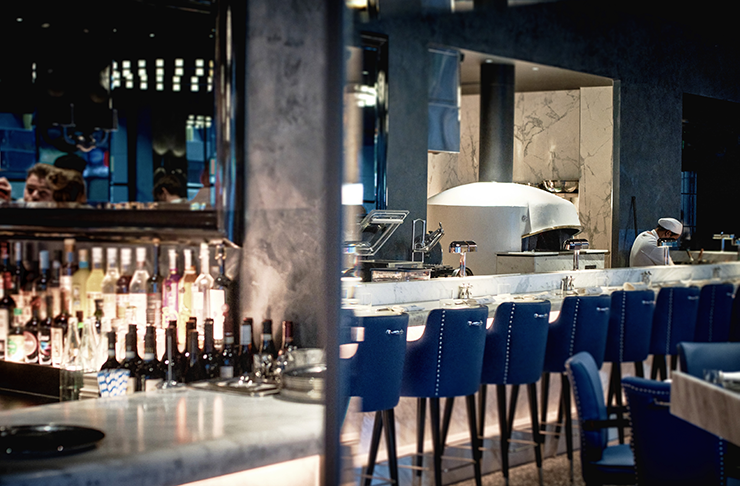 A bar with blue seats and marble benches.